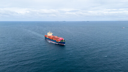 Aerial view of colorful cargo container ship sailing in open sea. Ideal for international shipping, maritime logistics, global trade, sea freight transport, and import-export business concepts.