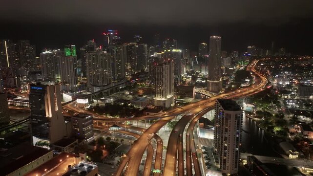 Cinematic panoramic aerial view of Brickell Miami skyline and I95 highway at night with clouds	
