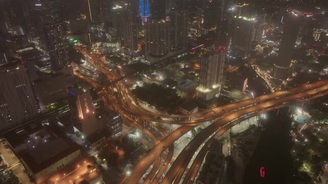 Cinematic panoramic aerial view of Brickell Miami skyline and I95 highway at night with clouds	

