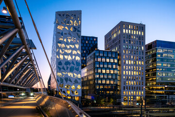 Akrobaten bridge in Oslo connecting the Barcode skyline with sleek modern architecture under soft evening light and reflective glass creating a calm panoramic urban atmosphere