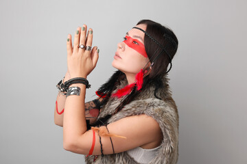 Shaman woman with face painting on light grey background