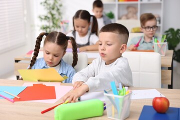 Obraz premium Children at wooden desk during art lesson in elementary school