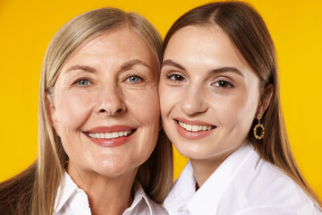 Mother and daughter on orange background. Family bonding