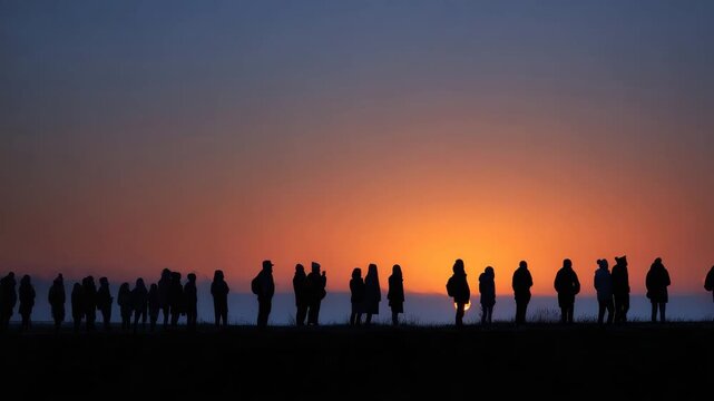 Individuals stand in silhouette as they enjoy a beautiful sunset together, sharing moments