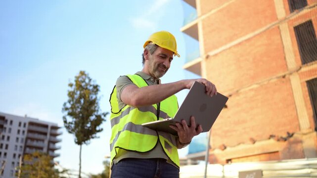 Construction manager using laptop on building site