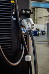 Modern electric vehicle charging station with connector, showcasing sustainable transport technology and infrastructure. Emphasizes clean energy and eco-friendly future.