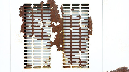 white perforated metal sheet severely damaged and covered in dark rust. Represents decay, industrial texture, aging, grunge background, damage, and corrosion concept.