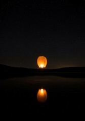 Obraz premium A couple of lanterns floating on top of a body of water