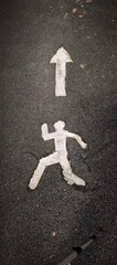 road marking showing a person running towards an arrow pointing up