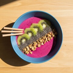 A bowl of fruit and granola with chopsticks on a table