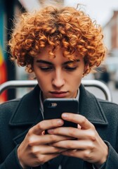 A woman with curly hair looking at her phone