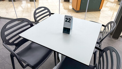 Sparse cafe tabletop sanctuary, a numeral anticipating hidden rendezvous, evokes Dia de la...