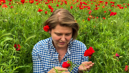 A contemplative Caucasian woman immersed in vibrant poppy fields feels the whisper of spring...