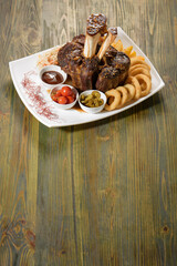 Beef shank on the bone with fermented cabbage, pickled tomatoes, baked potatoes, and teriyaki sauce