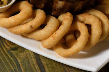 breaded onion rings with olives and mint leaves
