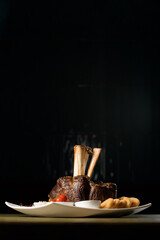 Beef shank on the bone with fermented cabbage, pickled tomatoes, baked potatoes, and teriyaki sauce