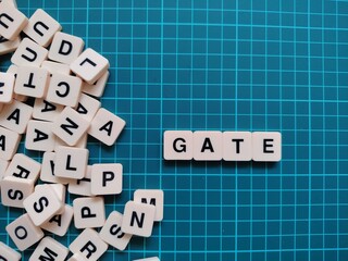 letters of the alphabet with the word GATE with scrambled other letters on the left. searching for words, education, crossword and quiz concept. bright green background.
