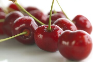 Close-up of fresh ripe cherries with shiny red skin and green stems