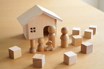 Wooden Toy House Family and Blocks representing Home Ownership and Financial Security with Focus and Shallow Depth of Field