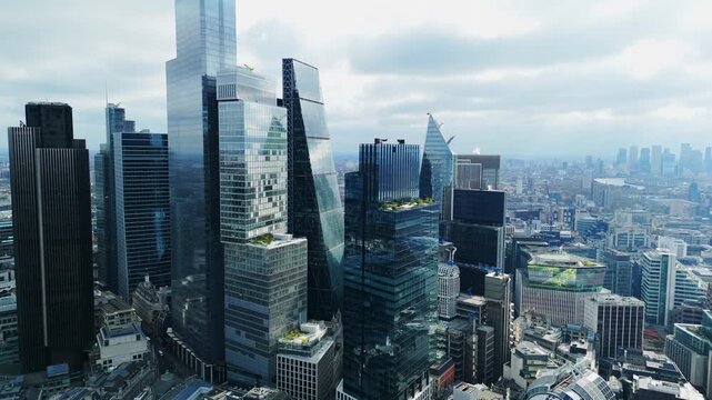 Aerial view of shimmering glass skyscrapers pierce the skyline, reflecting the soft, diffused light of the overcast sky, London, United Kingdom.