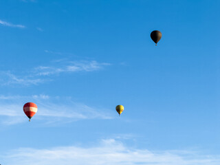 A hot air balloon flies over the city Yerevan, background of the blue sky. Aerial view of many colorful hot air balloons fly in the sky. High quality