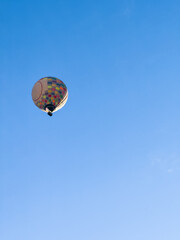 A hot air balloon flies over the city Yerevan, background of the blue sky. Aerial view of many colorful hot air balloons fly in the sky. High quality