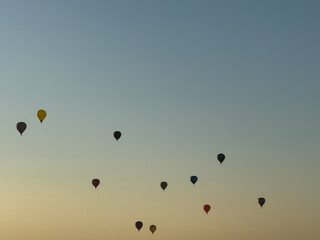 A hot air balloon flies over the city Yerevan, background of the blue sky. Aerial view of many colorful hot air balloons fly in the sky. High quality