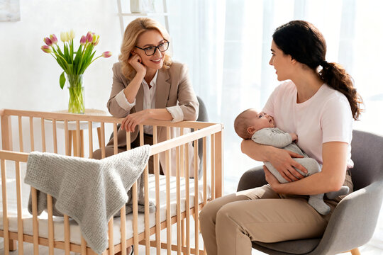 Female Psychologist Comforts Postpartum Mother Holding Baby, Offering Emotional Healing, Mental Health Support, and Gentle Compassion. copy space 