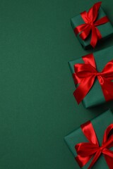 Beautiful gifts with red ribbons on green background