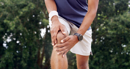 Fitness, hands and man with knee pain outdoor from sports injury, muscle fatigue and workout strain. PFPS, runner and kneecap dislocation in nature with joint inflammation, exercise sprain and bokeh
