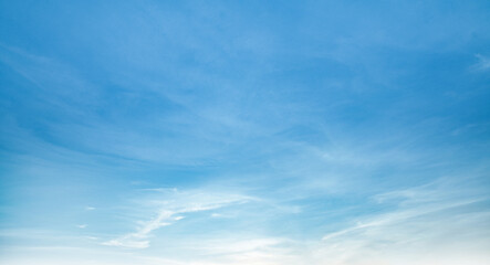 the sky is clear blue with fluffy white clouds, the sky is very bright, and the sun shines.