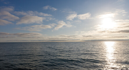 Fototapeta premium The sky is blue and the sun is shining on the water