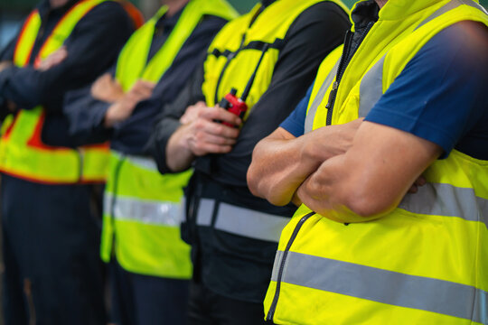 group of men in yellow safety vests stand together