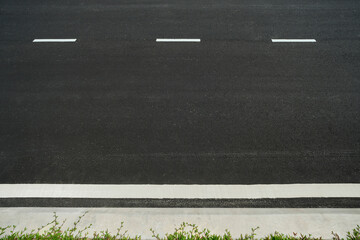 Empty asphalt road with white lane markings and curb