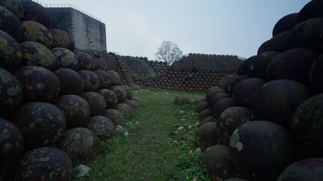 First-person walking between piles of old, rusty cannonballs, Citadelle Laferri&egrave;re, historic military fortress in Haiti