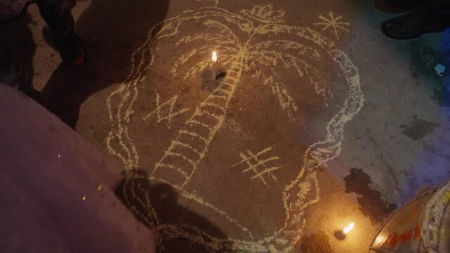 Voodoo veve symbol drawn on ground with powder and lit by candles, spiritual rituals and cultural heritage in Haiti