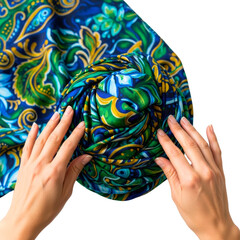 Woman's hands are folding a colorful paisley-patterned silk scarf isolated on transparent background