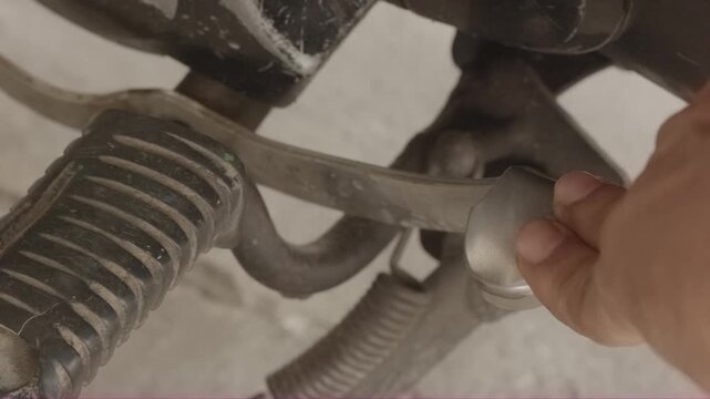 Mechanic hand shifting motorcycle gear lever close-up