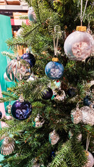 A decorated Christmas tree with various ornaments. The tree features green branches adorned with blue and silver baubles, creating a festive atmosphere.