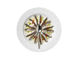 a plate of canned anchovies on a white background, seen from above

