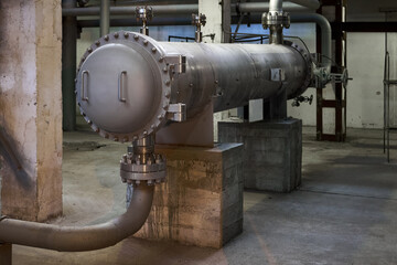 Industrial refinery 2 pass heat exchanger chiller with flanges and valves inside industrial workshop. Interior of enterprise industrial background with copyspace.
