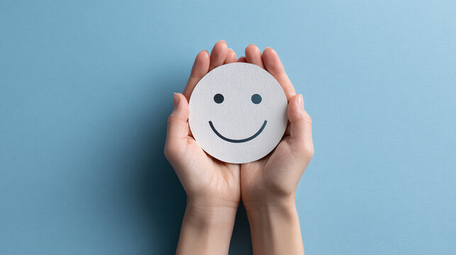 A person holding a happy face, expressing feelings of joy