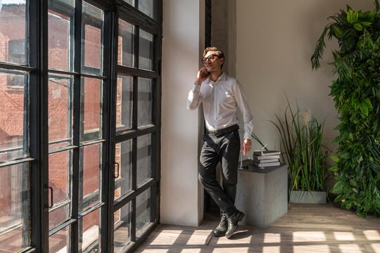 Businessman talking on mobile phone standing in office
