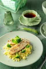 Fish fillet with couscous and broccoli on a plate