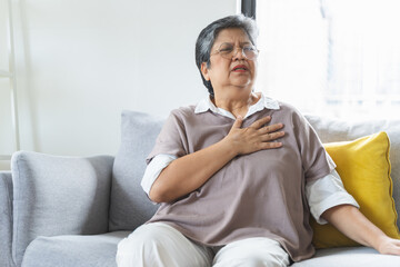 Fototapeta premium Chest pain, attack chest, emergency heartbeat asian senior woman holding hand on chest, suffering symptom from pain, heart disease problem of aged anxiety cardiac. Health care of cardiology concept.