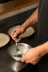 Hands cooking in restaurant kitchen