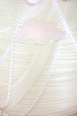 Soft white fabric with pearl beads and Happy Birthday sign. Luxury background for party, invitation, or branding design. Perfect for birthday