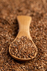 flax seeds for sowing in a wooden spoon, a large number of brown flax seeds and a wooden spoon with seeds