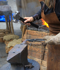 mujer herrera forjadora en el yunque trabajando con el martillo manos forja fuego 4M0A8235-as25