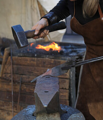 mujer herrera forjadora en el yunque trabajando con el martillo manos forja fuego 4M0A8451-as25